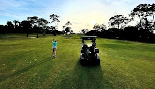 Golfer and golf cart on grounds of Hidden Hills Golf Club in Jacksonville FL